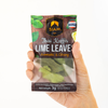Hand holding a package of Siam Thai Kaffir Lime Leaves on a white background