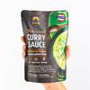 Packaged Thai Green Curry Sauce with Siam branding held by a hand on a white background